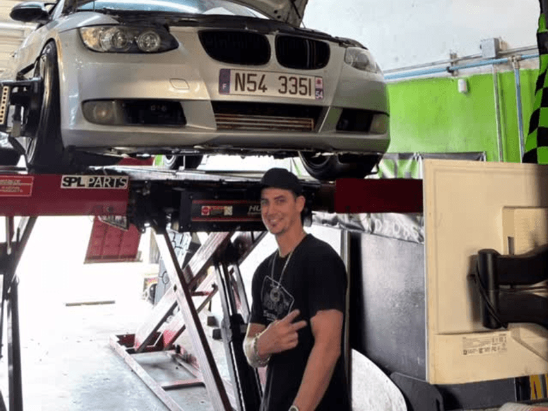 BMW 335i in for service, hood up in the Davie shop